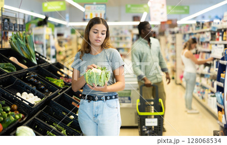 Young girl buying cauliflower at market Young girl buying cauliflower at market 128068534