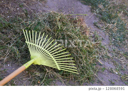 Green plastic mop sweeping trash in the yard Green plastic mop sweeping trash in the yard 128068591