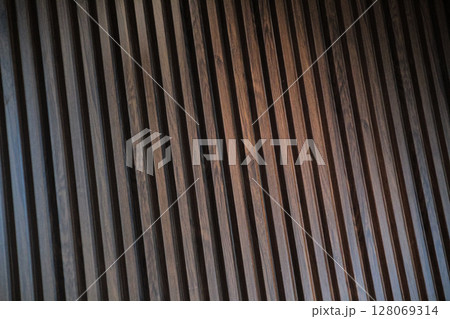 Vertical brown wood slats forming a modern decorative paneling texture 128069314