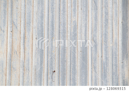 Grungy vertical lines on old corrugated metal building siding backdrop 128069315