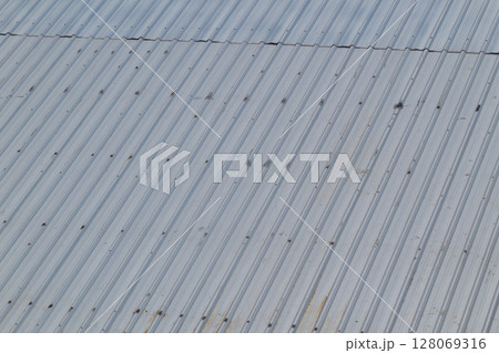 Detailed diagonal view of weathered gray corrugated metal roof surface Detailed diagonal view of weathered gray corrugated metal roof surface 128069316