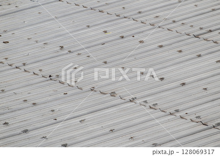 Detailed diagonal view of weathered gray corrugated metal roof surface Detailed diagonal view of weathered gray corrugated metal roof surface 128069317
