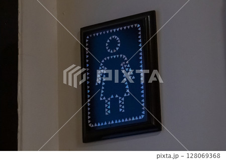Framed womens restroom sign featuring geometric triangular pattern on blue background Framed womens restroom sign featuring geometric triangular pattern on blue background 128069368