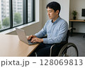 車椅子の男性がオフィスで仕事をする様子 128069813