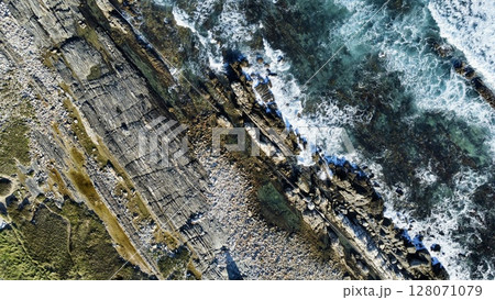 Striated Coastal Cliffs Meeting Turbulent Turquoise Seas 128071079