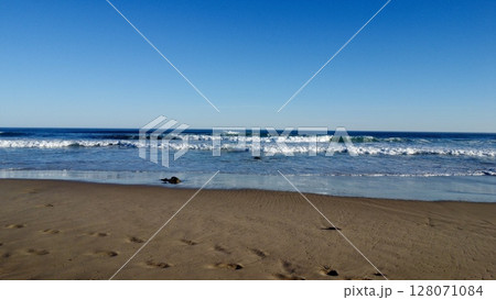 Morning Footsteps Along Serene Sandy Shoreline 128071084
