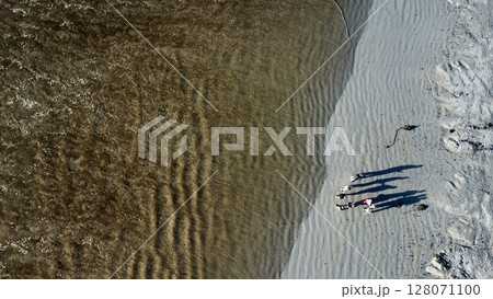 Gathered Shadows Amidst Rippling Coastal Shoreline Patterns 128071100