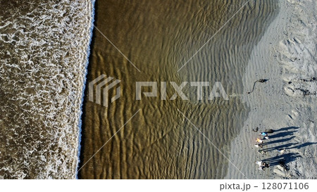 Gathered Shadows Amidst Rippling Coastal Shoreline Patterns 128071106