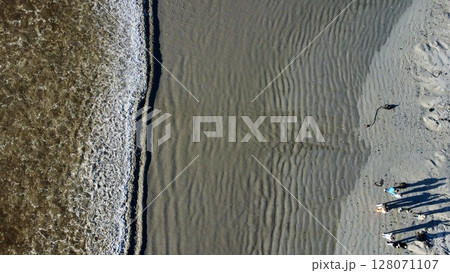 Gathered Shadows Amidst Rippling Coastal Shoreline Patterns 128071107