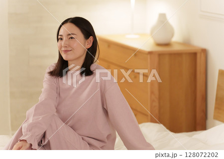 夜ベッドでストレッチする女性 128072202