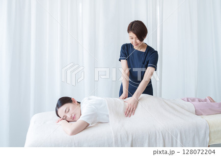 客に施術するエステティシャン 客に施術するエステティシャン 128072204