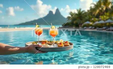 A resort-style floating tray with drinks and delicacies on a table by the pool, ideal for a relaxing luxury experience 128072469