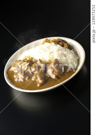 大きな鶏肉がゴロゴロと入っている熱々チキンカレーを黒背景で撮影 128073252