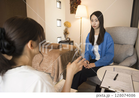 エステサロンでカウンセリングと注意事項を受ける若い女性 エステサロンでカウンセリングと注意事項を受ける若い女性 128074086