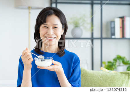 ヨーグルトを食べるミドルの女性 128074313