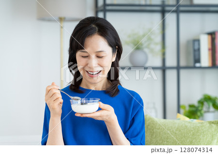 ヨーグルトを食べるミドルの女性 128074314