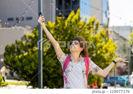 Tourist with backpack trying to catch a communication signal and Internet connection on mobile phone 128077176