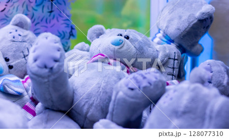 A delightful group of cuddly teddy bears is laying on top of one another 128077310