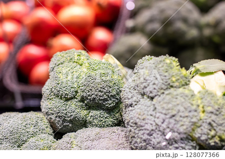 A bunch of broccoli is stacked together in a grocery store 128077366
