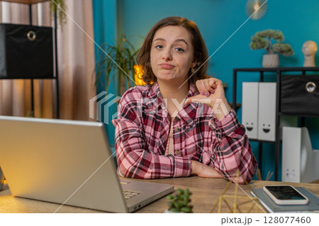 Businesswoman working on laptop computer at home office showing thumbs down sign dislike disapproval Businesswoman working on laptop computer at home office showing thumbs down sign dislike disapproval 128077460