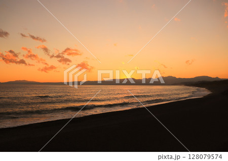 海辺の夕焼け空に浮かぶオレンジの雲 128079574