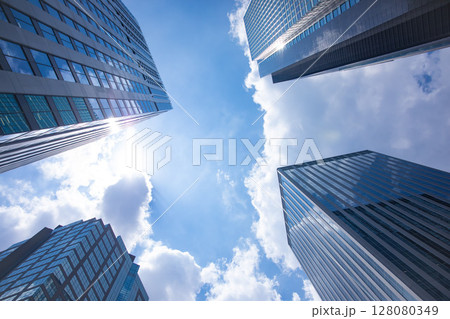 オフィスビルの窓ガラスに反射する雲【都市イメージ】 オフィスビルの窓ガラスに反射する雲【都市イメージ】 128080349