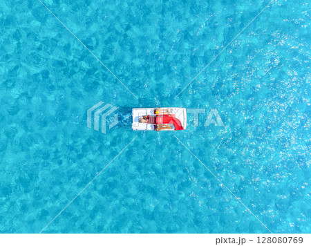 Catamaran and water slide jumping. People relax at the sea. Vacation and holiday on the sea coast. Catamaran and water slide jumping. People relax at the sea. Vacation and holiday on the sea coast. 128080769