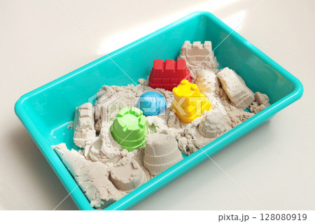 Kinesthetic sand and shapes in sandbox for children. Toys and motor skills development. Royal castle, tower and construction site. Kinesthetic sand and shapes in sandbox for children. Toys and motor skills development. Royal castle, tower and construction site. 128080919