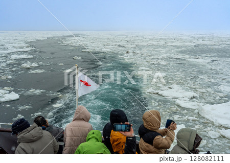 北海道網走市　流氷観光砕氷船おーろら号からの流氷の海面を写真に撮る観光客 128082111