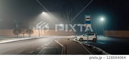 Foggy Night Bus Stop with Lone Car and Streetlights Foggy Night Bus Stop with Lone Car and Streetlights 128084064
