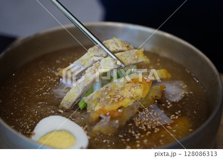 Close-up of Korean Naengmyeon Cold Noodles Topped with Sliced Beef Pancake (Yukjeon) Close-up of Korean Naengmyeon Cold Noodles Topped with Sliced Beef Pancake (Yukjeon) 128086313