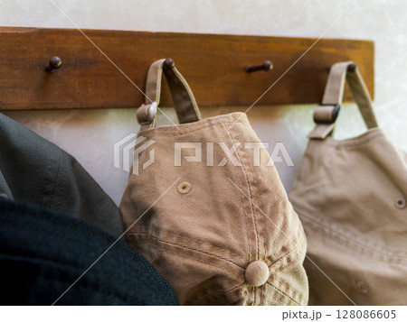 木製フックに掛けられたカジュアルな帽子 128086605