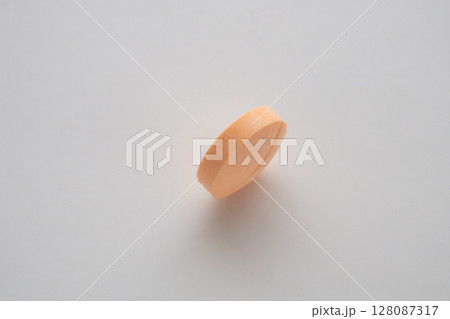 Orange medicine pill tablet on white background 128087317