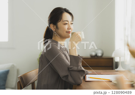自宅でデスクに向かう女性 128090489