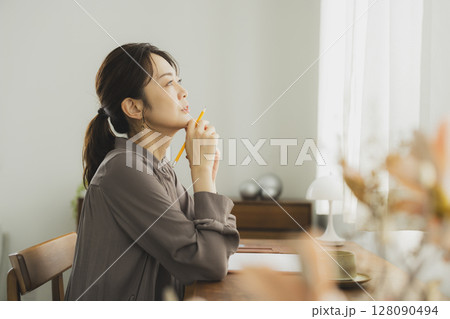 自宅でデスクに向かう女性 128090494