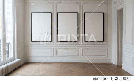 Empty frames hang on a white wall in a spacious room with elegant molding and wooden flooring, illuminated by natural light Empty frames hang on a white wall in a spacious room with elegant molding and wooden flooring, illuminated by natural light 128090824