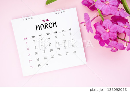 March 2026 desk calendar and pink orchid on pink color background. March 2026 desk calendar and pink orchid on pink color background. 128092038