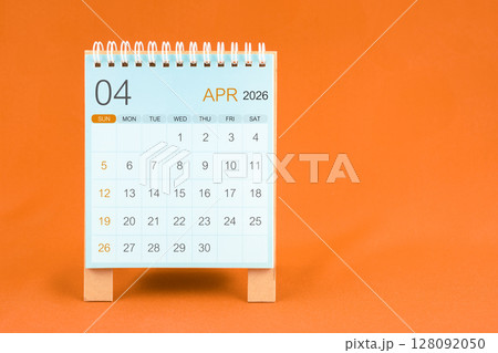 April 2026 desk calendar stand on orange color textile background. April 2026 desk calendar stand on orange color textile background. 128092050