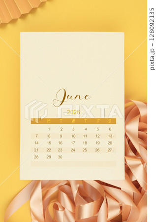 June 2026 calendar page with yellow ribbon on yellow background. 128092135