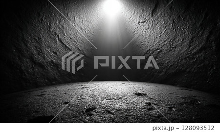 天井から光が差し込む暗闇の空間と荒れた岩肌 128093512