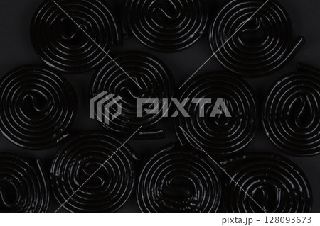 Spiral black background. Licorice candy in the form of a spiral close-up. 128093673
