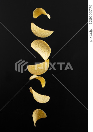 Chips on a black background. Flying potato chips. Chips on a black background. Flying potato chips. 128093776