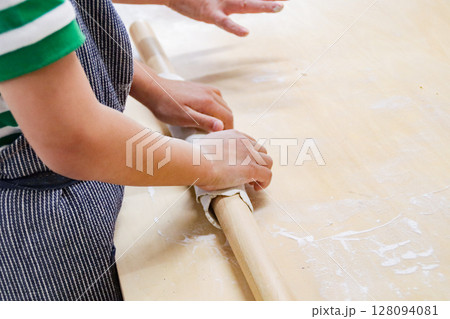 蕎麦生地を麺棒で伸ばす子供(7歳児/男の子) 蕎麦生地を麺棒で伸ばす子供(7歳児/男の子) 128094081