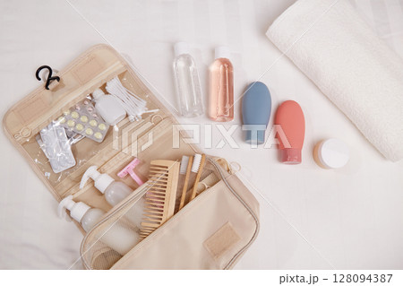 A travel toiletry kit is neatly laid out on a white surface. It includes essential personal hygiene items A travel toiletry kit is neatly laid out on a white surface. It includes essential personal hygiene items 128094387