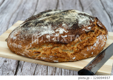 Rustic homemade bread on wooden cutting board 128094937