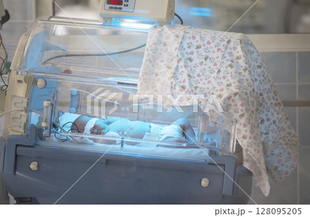 Newborn baby in the medical box at the hospital.Closeup of an infant incubator technology in a medical center hospital 128095205