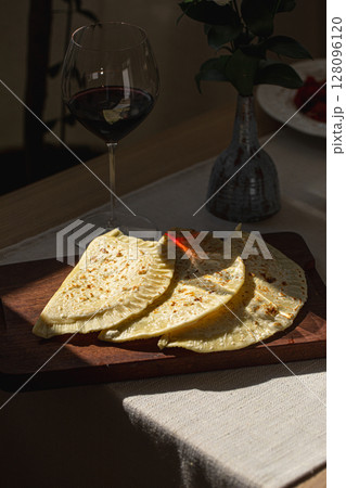 Qutab flatbreads on board with glass of red wine 128096120