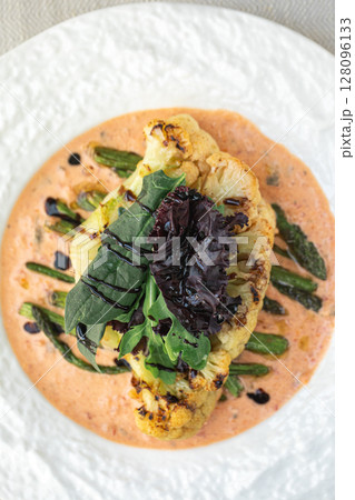 Cauliflower steak with asparagus and sauce Cauliflower steak with asparagus and sauce 128096133