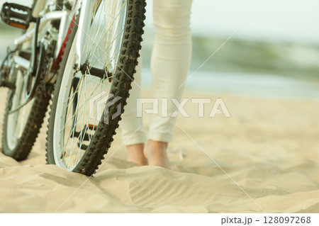 Unrecognizable woman bike cycling on sand 128097268