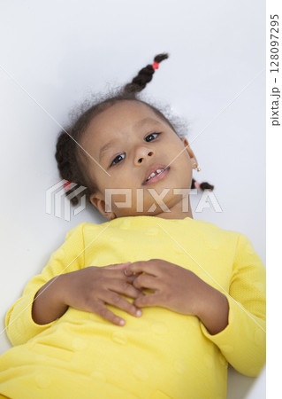 Portrait of a funny little African American girl with pigtails. Portrait of a funny little African American girl with pigtails. 128097295